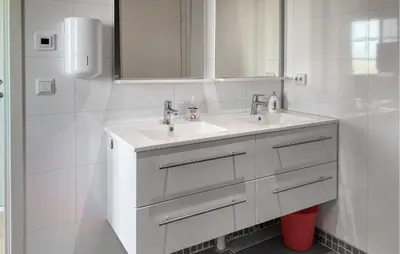 a white bathroom with a sink and a mirror at Beautiful Home In Fjørtoft With Wifi in Fjørtoft