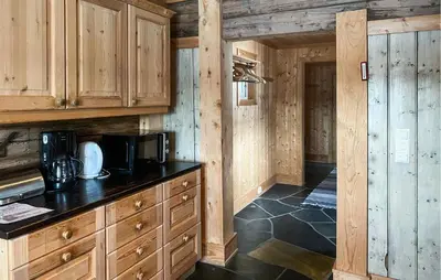 a kitchen with wooden cabinets and a counter top at Cozy Home In Fåvang With Wifi in Favang