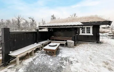 a hut with a bench and a table in the snow at Fantastisk Hytte På Lenningen in Etnedal