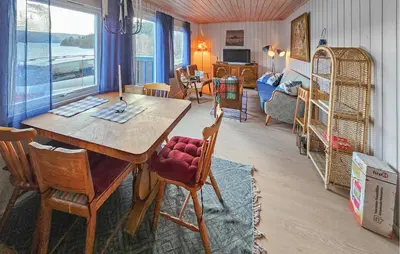 a living room with a wooden table and chairs at 2 Bedroom Awesome Home In Vikersund in Vikersund