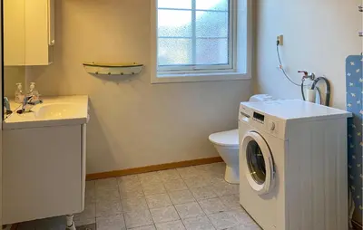 a bathroom with a washing machine and a sink at 2 Bedroom Beautiful Home In Frosta