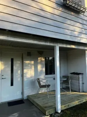 a porch with two chairs and a table on a house at Apartments near Bergen Airport in Bergen