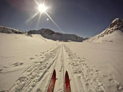 a pair of skis in the snow with the sun at Cozy apartment near ski attractions in Geilo
