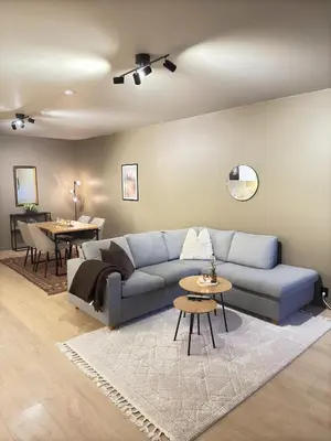 a living room with a blue couch and tables at Cozy apartment near ski attractions in Geilo