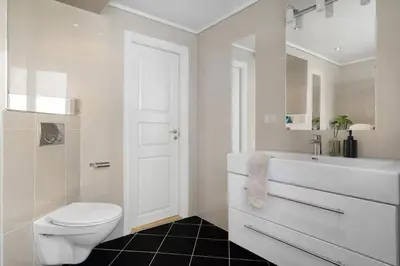a white bathroom with a toilet and a sink at Leilighet i Sandviken in Bergen