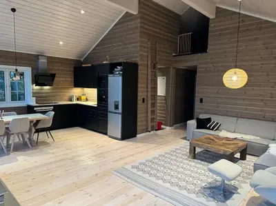 a kitchen and living room with a couch and a table at Skogshytte på Skreia in Brattlia