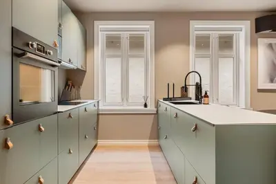 a kitchen with white cabinets and a counter top at Odda Central Apartment in Odda