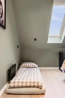 a bed in a white room with a window at Odda Central Apartment in Odda