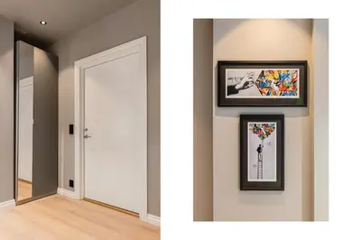 a hallway with two pictures on the wall and a white door at Odda Central Apartment in Odda