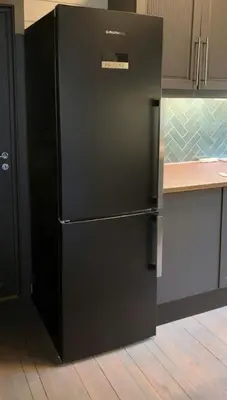 a black refrigerator in a kitchen next to a counter at Mountain Cabin With Magical View And Tranquil Lake in Matre