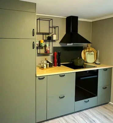 a kitchen with a counter with a stove and a refrigerator at Charming Seaside Cabin With Amazing View in Hardbakke