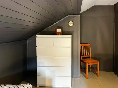 a room with a dresser and a chair at Charming Seaside Cabin With Amazing View in Hardbakke