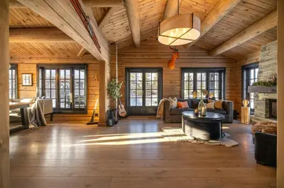 a living room with wooden walls and a wooden ceiling at Modern Log Cabin With Hot Tub And Sauna in Veggli