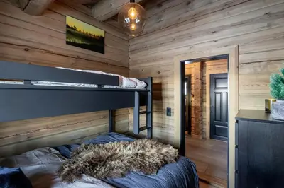 a bedroom with a bunk bed in a wooden cabin at Modern Log Cabin With Hot Tub And Sauna in Veggli