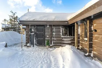 a wooden cabin in the snow with snow around it at Modern Log Cabin With Hot Tub And Sauna in Veggli