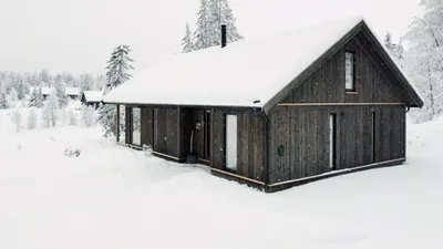 a wooden barn in the snow at Charming Summer Farm Hut At Sjusjøen in Torpo
