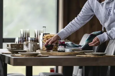 a person is serving food on a table at Modern And Inviting Cabin In Valdres in Aurdal