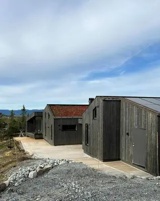 two large wooden buildings sitting next to each other at Stylish Mountain Cabin In Hallingdalen in Flå