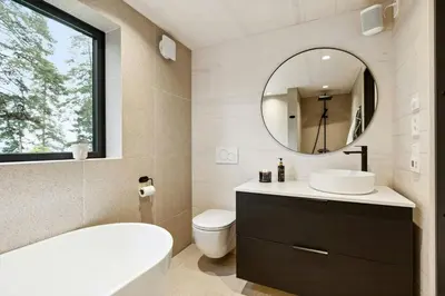 a bathroom with a tub and a sink and a mirror at New Cabin By Tyrifjorden For Relaxing Holidays in Gjesval