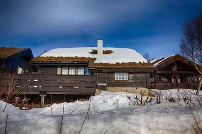 a wooden house with snow on top of it at A Cozy, Rustic Retreat With Fireplace And Terrace in Beitostøl