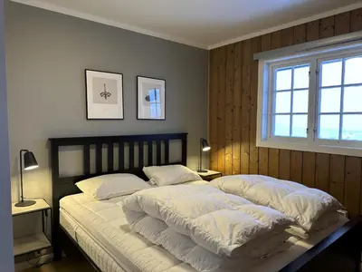 a bedroom with a large bed with white blankets and pillows at Modern 2-Bedroom Apartment In Ideal Location in Beitostøl