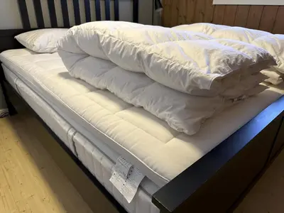a bed with white sheets and pillows on it at Modern 2-Bedroom Apartment In Ideal Location in Beitostøl