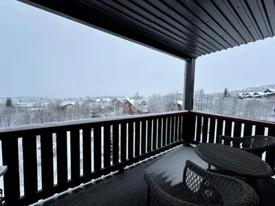 a screened in porch with two chairs and snow on the ground at Modern 2-Bedroom Apartment In Ideal Location in Beitostøl