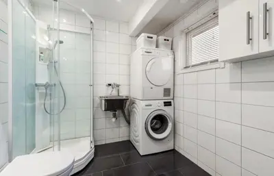 a bathroom with a washing machine and a shower at SKI VM TRONDHEIM 2025- Private home in Tiller