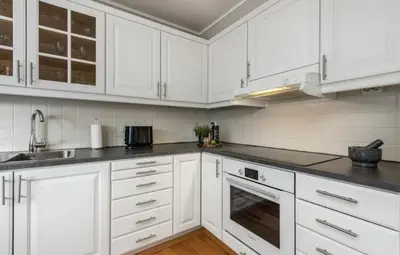 a white kitchen with white cabinets and a sink at SKI VM TRONDHEIM 2025- Private home in Tiller