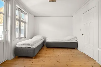 two beds sitting in a room with a window at Bryggen Historical Townhouse I Rooftop Views! in Bergen