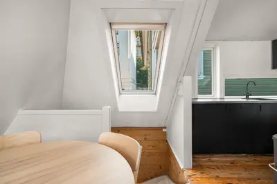 a kitchen with a sink and a table in a room at Bryggen Historical Townhouse I Rooftop Views! in Bergen