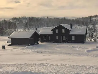 two houses with snow covered roofs in a snowy field at Cozy Cabin With Ski Trail Access in Beitostøl