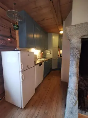 a kitchen with green cabinets and a white refrigerator at Brattland Sæter in Strond