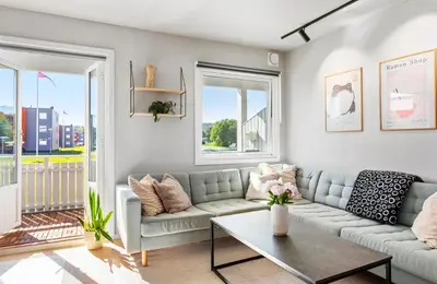 a living room with a couch and a table at Lys og koselig leilighet leies ut til Ski VM 2025 in Trondheim