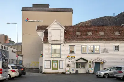 a building with cars parked in front of it at 3-roms leilighet i hjertet av Sandviken in Bergen