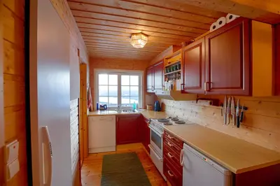 a kitchen with wooden cabinets and a counter top at Ski-In Ski-Out Cozy Retreat With Mountain Views in Beitostøl