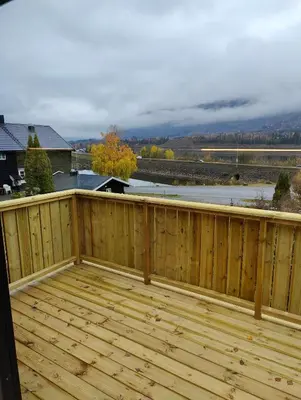 a wooden deck with a view of a field at Nye leiligheter på Blomberg i Hafjell in Hafjell