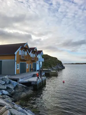 a house on a dock next to a body of water at Stor hytte med fantastisk utsikt in Vikso