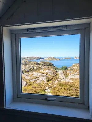 a window in a room with a view of a lake at Stor hytte med fantastisk utsikt in Vikso