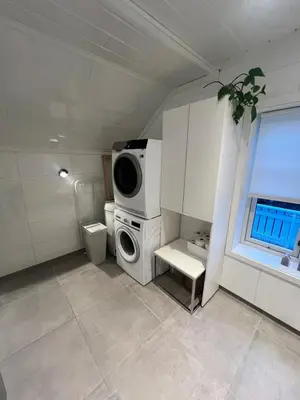 a bathroom with a washing machine and a window at Cozy apartment on the hill in Trondheim