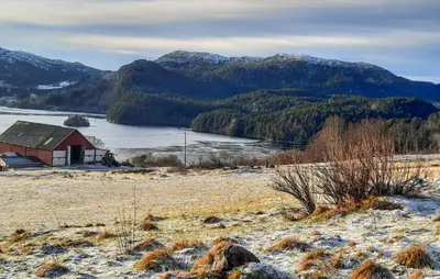 a house in a field with a lake and mountains at Stunning Home In Øydegard in Nastad