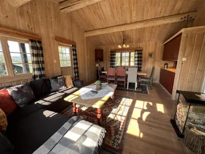 a living room with a couch and a table at Nostalgic Cabin With 3 Br, Fireplace, And Terrace in Beitostøl