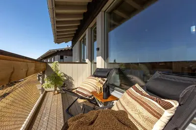a balcony with chairs and a table on a house at New modern apartment with ski in out in Hafjell in Hafjell