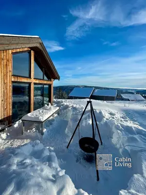 a house covered in snow with a bench in the snow at New modern cabin at Norefjell with sauna in Noresund