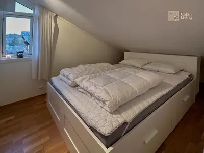a large bed in a room with a window at Modern apartment Hovden ski in-out x-skiing, 2 bathrooms and balcony in Hovden