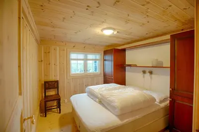 a bedroom with a bed in a wooden room at Peaceful Cabin Close To Beitostølen Center&Nature in Beitostøl