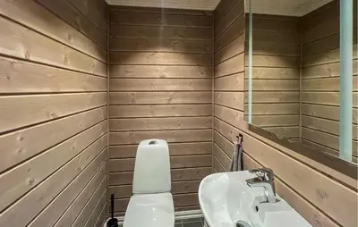 a bathroom with a toilet and a sink and a mirror at Moderne Hytte Midt I Skibakken in Ryfoss