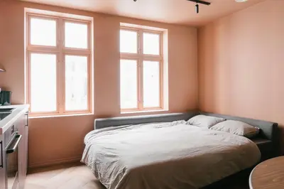 a bedroom with a large bed with two windows at New Apartment in Historical street in Bergen