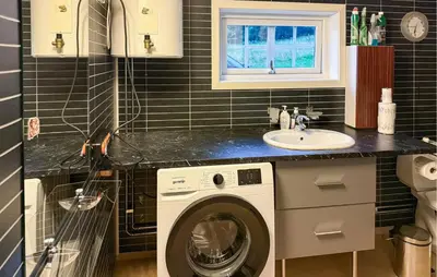 a bathroom with a washing machine and a sink at 1 Bedroom Beautiful Home In Korssund in Korssund