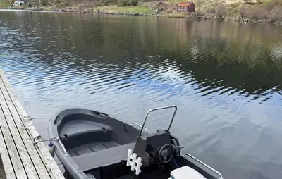 a boat tied to a dock on a body of water at 1 Bedroom Beautiful Home In Korssund in Korssund